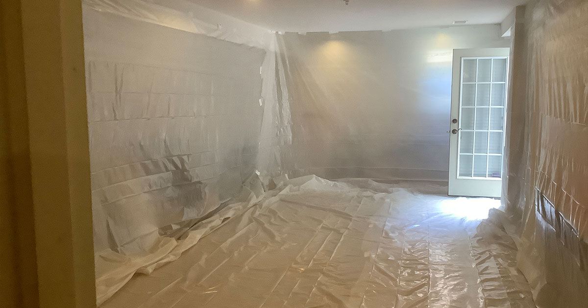 basement painting with everything covered in plastic