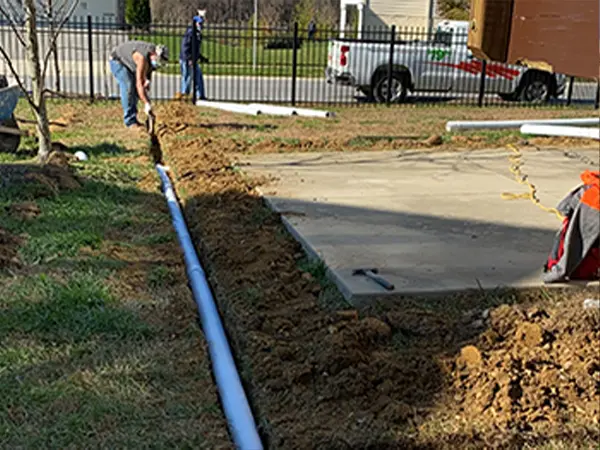 Contractors digging in backyard and installing pipes