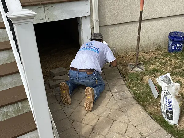 Capstone contractor on his knees to fix a bathroom
