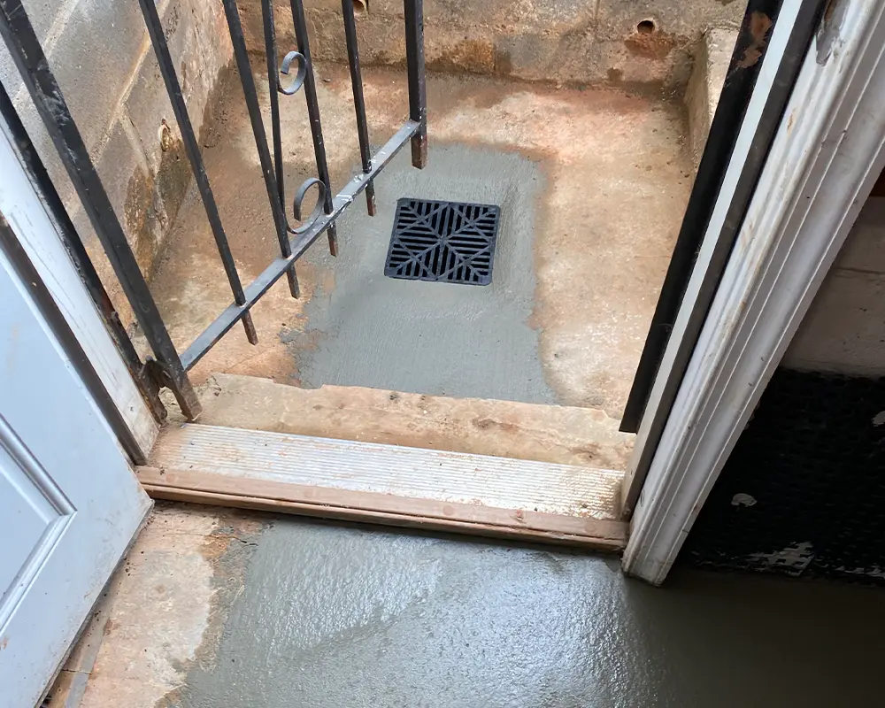 A drain at the front door of a walk-up basement