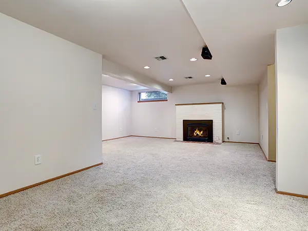 Carpet flooring in a basement with a fireplace