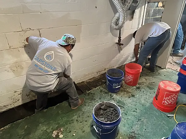 The team at Capstone working on a basement waterproofing