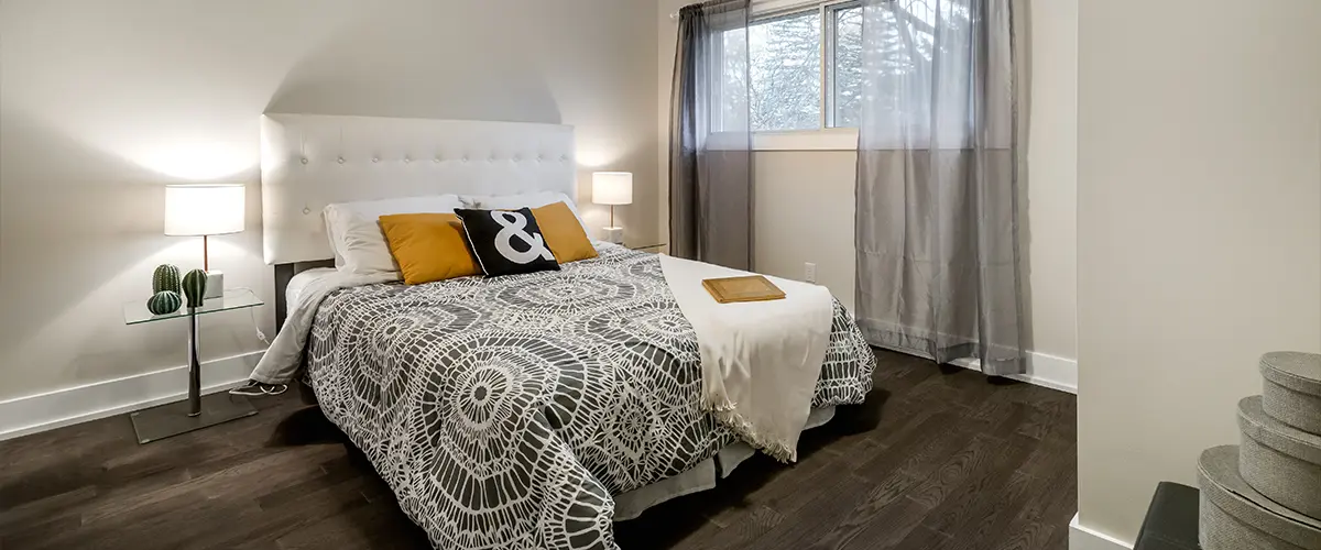 A bedroom in a basement space with an egress window