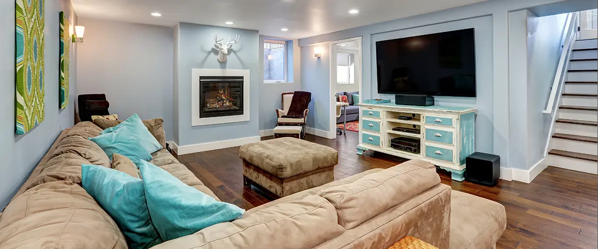 Remodeled basement with beige tones and pops of turquois color.
